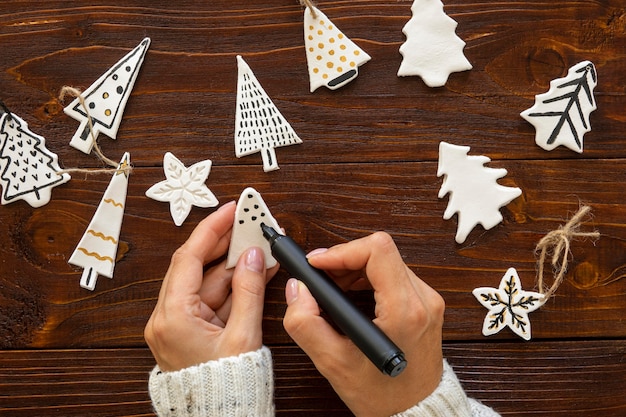 Flay lay of hands drawing on christmas tree decorations