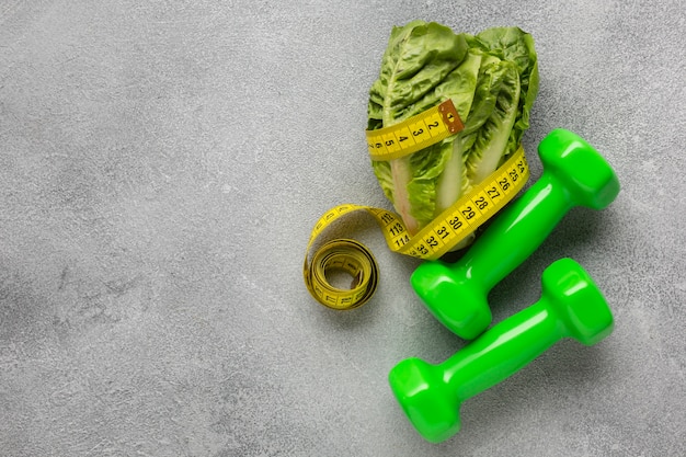 Free photo flay lay of lettuce and weights