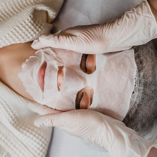 Flay lay of young woman getting a skin mask treatment