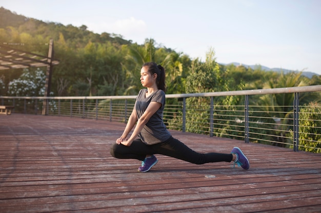 Flexible girl stretching her legs outdoors