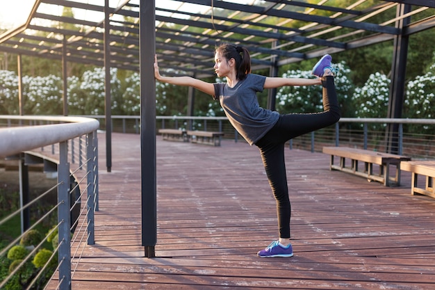 무료 사진 그녀의 왼쪽 다리를 기지개하는 유연한 sportswoman