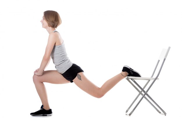 Flexible woman stretching with a chair