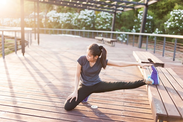 Free photo flexible woman stretching with leg on a bench