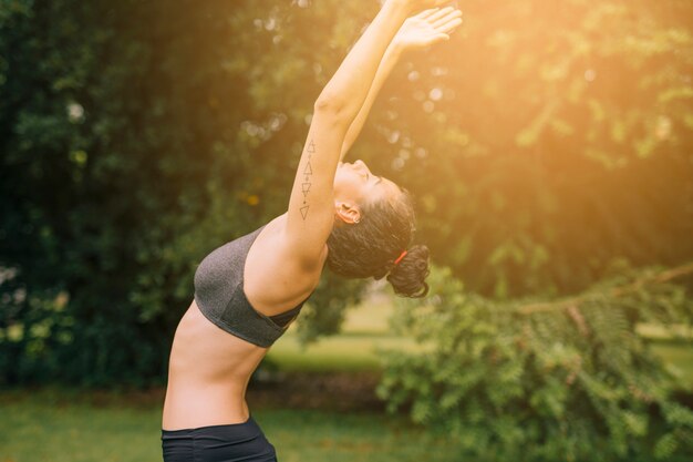 Flexible young woman exercising in the garden