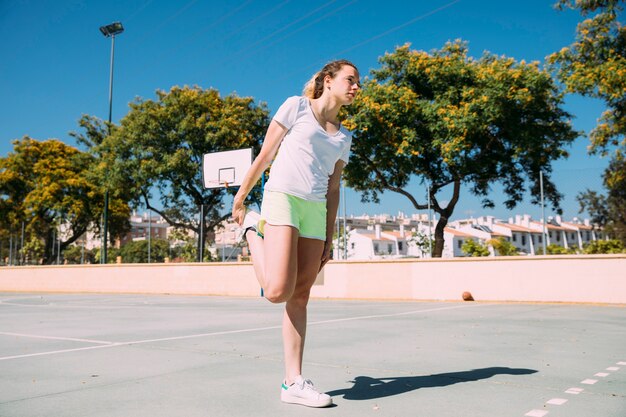 Flexible young woman warming up legs