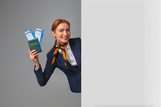 Free photo flight attendant holding plane tickets and passport