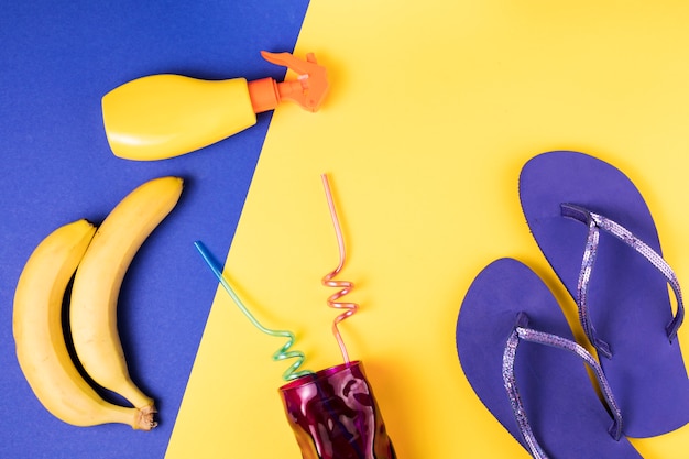 Flip flops near spray and fruits with glass with straws