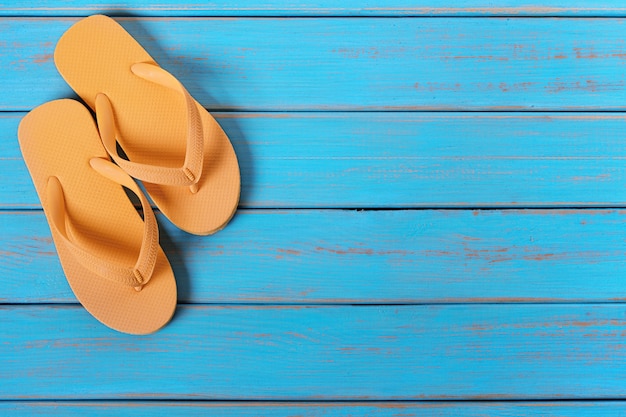 Free photo flip flops on old weathered blue beach wood