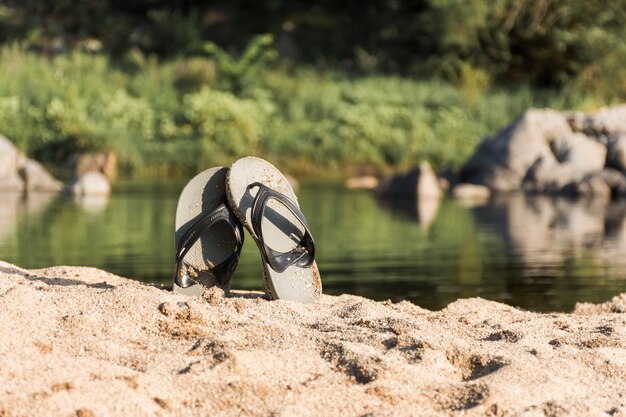 Flip flops on sand coast near water