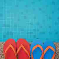 Free photo flip flops next to the swimming pool