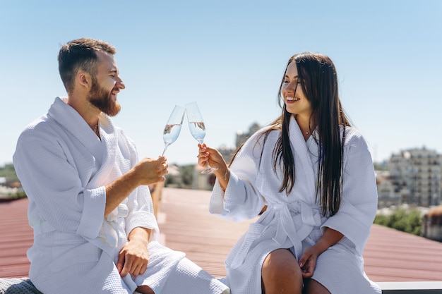 Flirting couple with sparkling wine on a roof