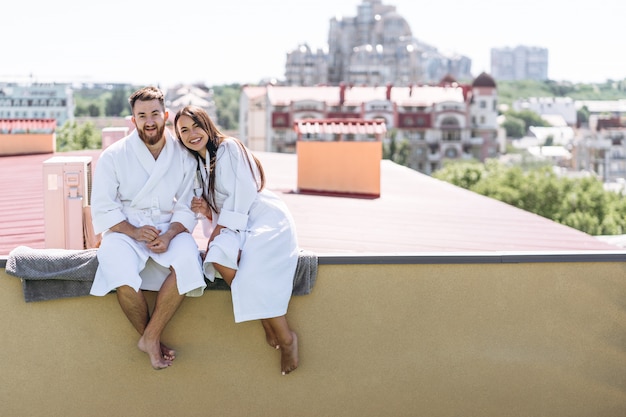 Free photo flirting couple with sparkling wine on a roof