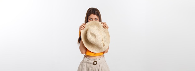 Flirty funky caucasian woman hiding behind fashionable trendy red head wear with wide open eyes