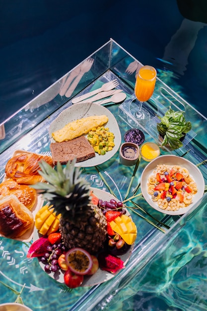 Foto gratuita colazione galleggiante nella splendida villa dell'hotel nella piscina blu