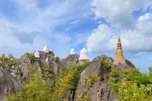 무료 사진 태국 람팡 채 홈 지구에 있는 왓 찰로엠 프라 키앗 프라 밧 푸파 댕 사원의 산 정상에 떠 있는 탑