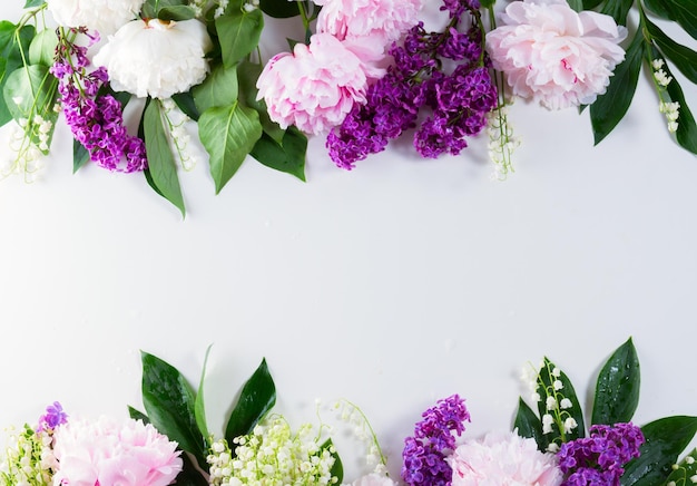 Floral borders - lilac, peonies and lilly of the walley flowers on white background with copy space