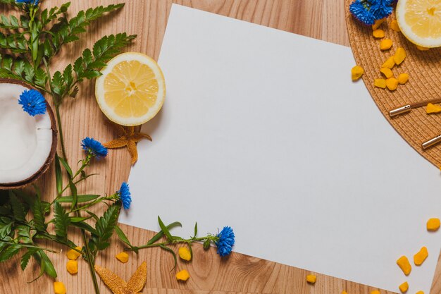 Floral composition with white paper, lemmon and coconut