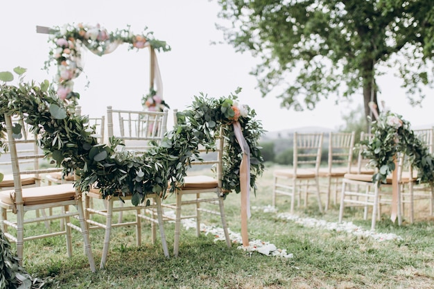 Floral compositions made of greenery at the outdoors wedding ceremony