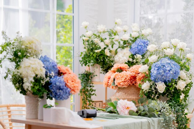 花の花束ビジネスショップ美しい生花あじさい白いバラと天然のバスケットは、花の小さなビジネスショップの朝の光のテーブルに注文して配置します