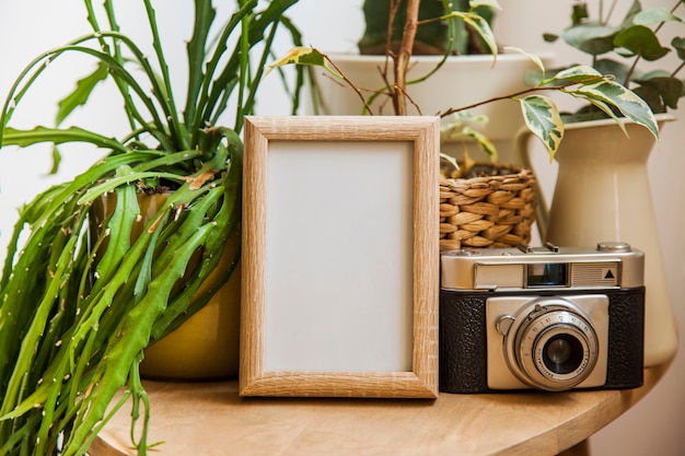 Free photo floral table decoration with frame and camera