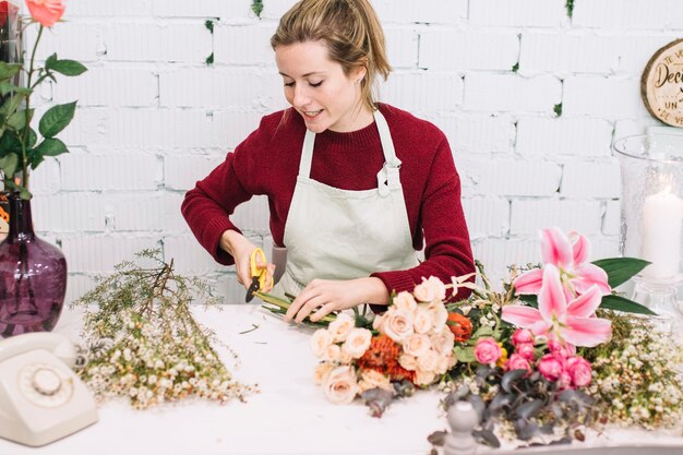 Free photo florist cutting stems of flowers