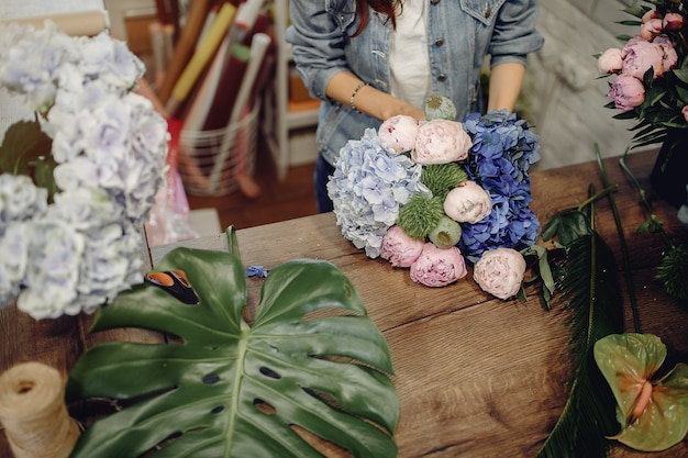 Foto gratuita fiorista in un negozio di fiori che fa un mazzo di fiori