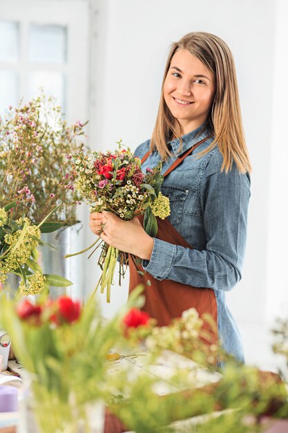 florist making bouquet of different flowers