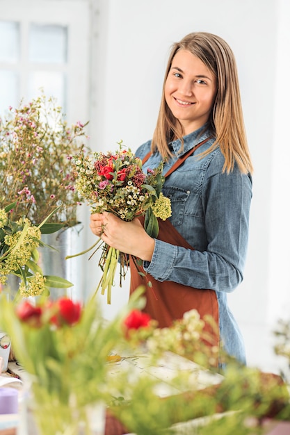 florist making bouquet of different flowers