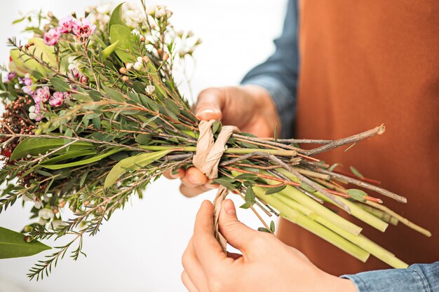 florist making bouquet of different flowers