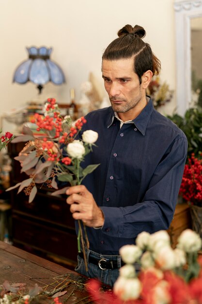 Florist male being focused and surrounded by flowers