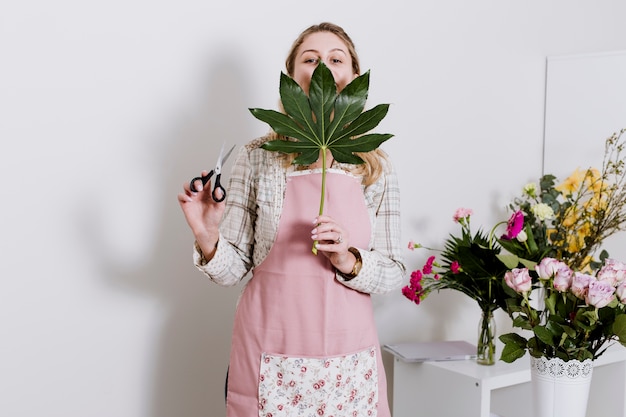 Florist posing with scissors and leaf