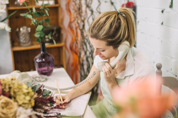 Florist speaking on phone and making notes