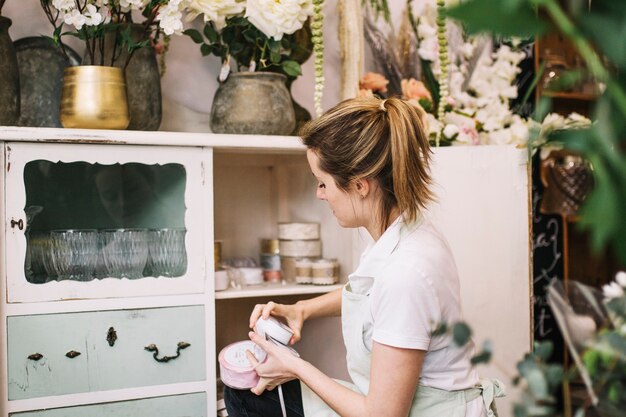 Florist taking decorations from cupboard