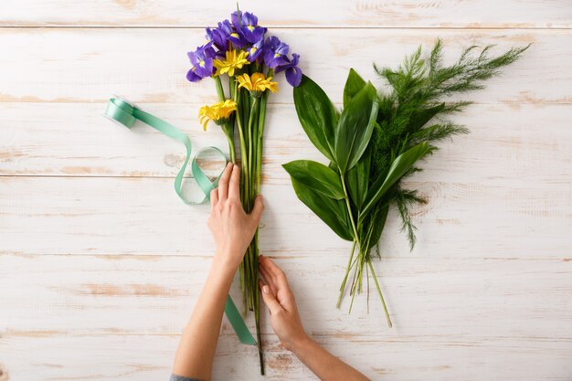 Florist woman hands, make bouquet of colorful flowers