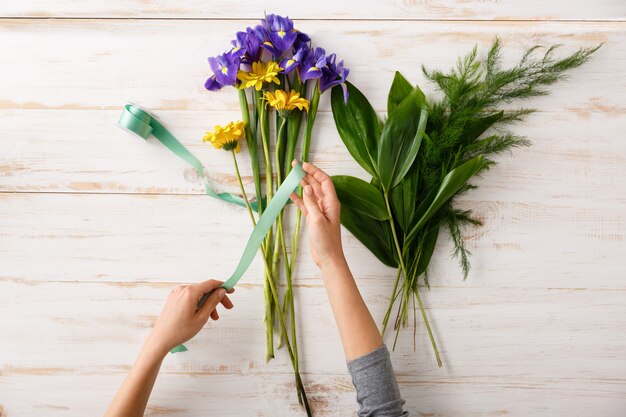 Florist woman hands, make bouquet of colorful flowers