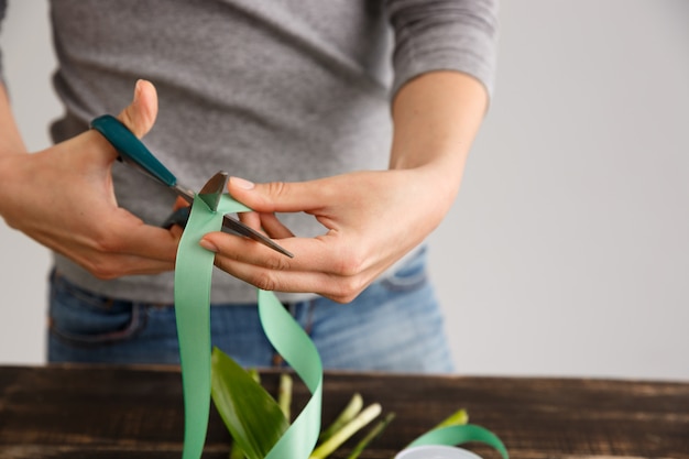 Florist woman make bouquet, cut decore ribbon