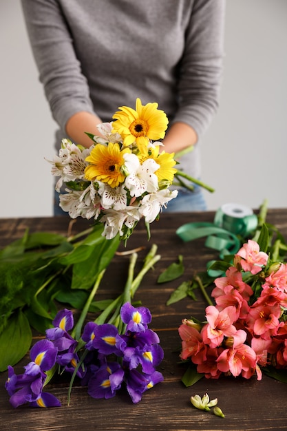 Florist woman make bouquet from colorful flowers