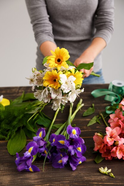 Florist woman make bouquet from colorful flowers