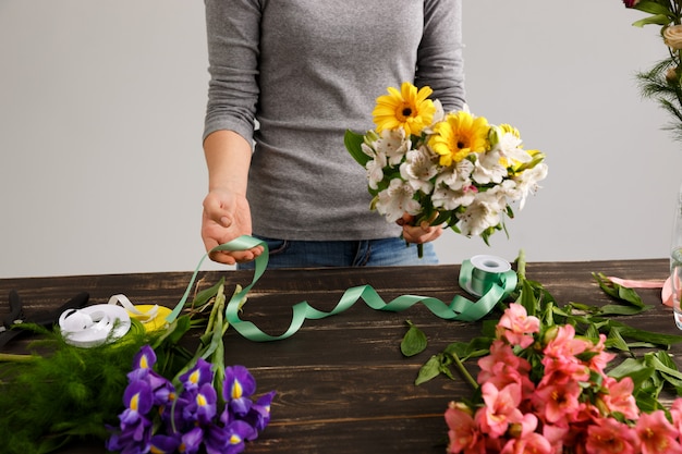 La donna del fiorista fa il mazzo dai fiori variopinti