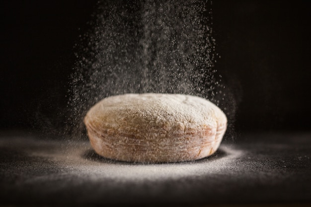 Flour being sprinkled on fresh baked bread
