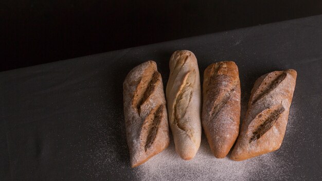 Flour dusted on baked bread over black background