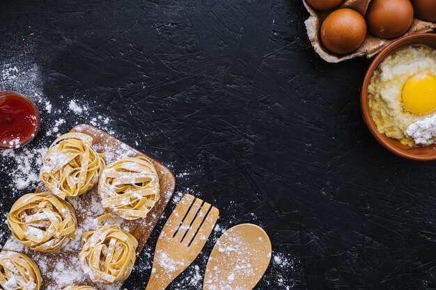 Flour and eggs near pasta and tools