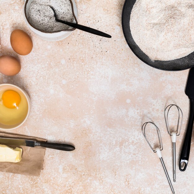 小麦粉;卵;卵黄バターとテキストを書くためのスペースとキッチンカウンターの上で泡立て器