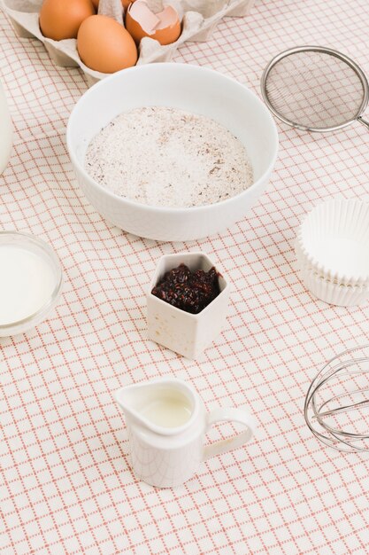 Flour; milk; egg; and baking utensils arranged on desk