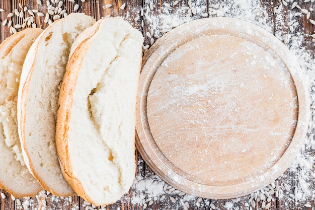 Flour spread over the round chopping board over the table