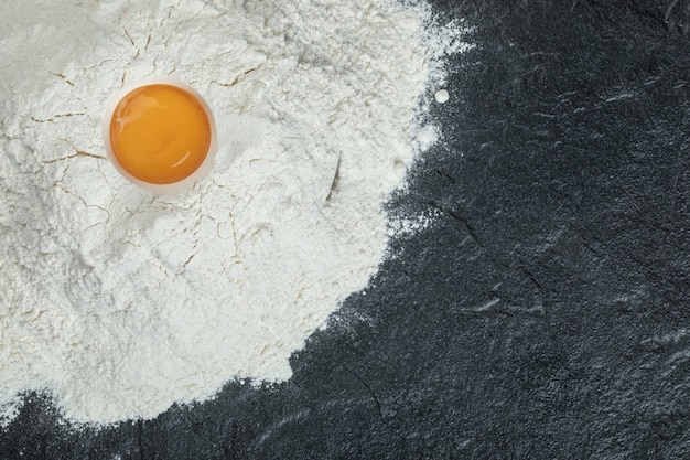 Flour with raw yolk on a gray background. 