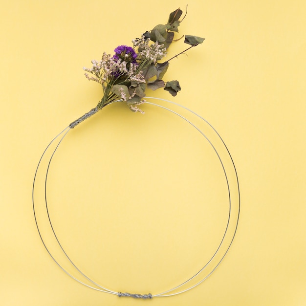 Flower bouquet on empty metallic ring over the yellow backdrop