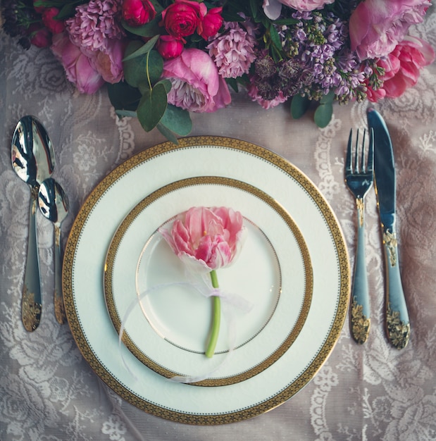 花の花束と白い皿の中のピンクのチューリップ。
