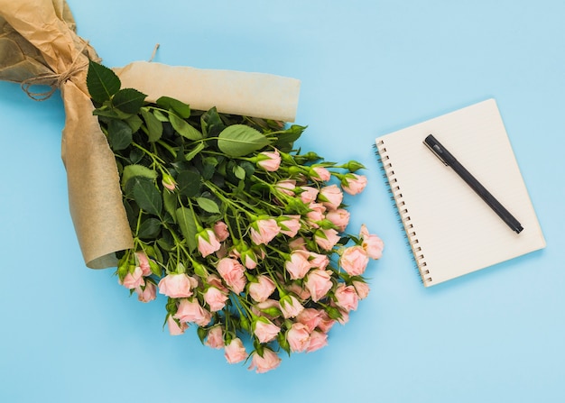 花束;スパイラルメモ帳とペン、青い背景
