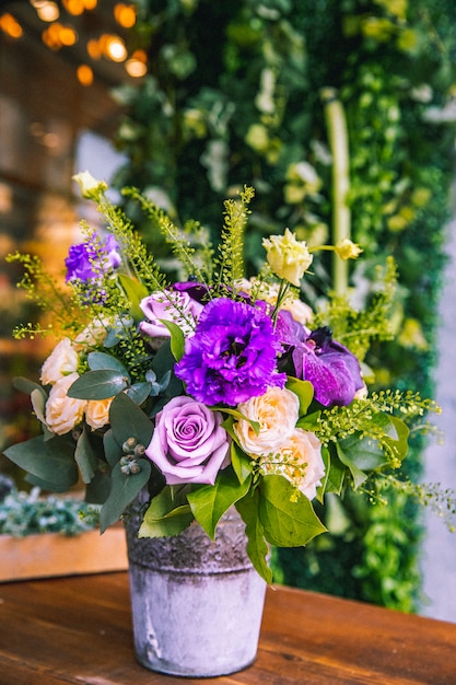 Flower composition in the bucket cream and purple roses lithianthus side view